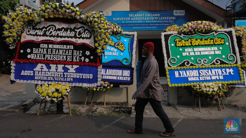 Warga berjalan di dekat karangan bunga duka cita di rumah duka Wakil Presiden ke-9 Hamzah Haz di Jalan Tegalan, Matraman, Jakarta, Rabu (24/7/2024). (CNBC Indonesia/Faisal Rahman)