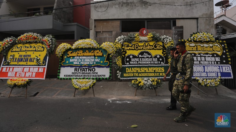 Warga berjalan di dekat karangan bunga duka cita di rumah duka Wakil Presiden ke-9 Hamzah Haz di Jalan Tegalan, Matraman, Jakarta, Rabu (24/7/2024). (CNBC Indonesia/Faisal Rahman)