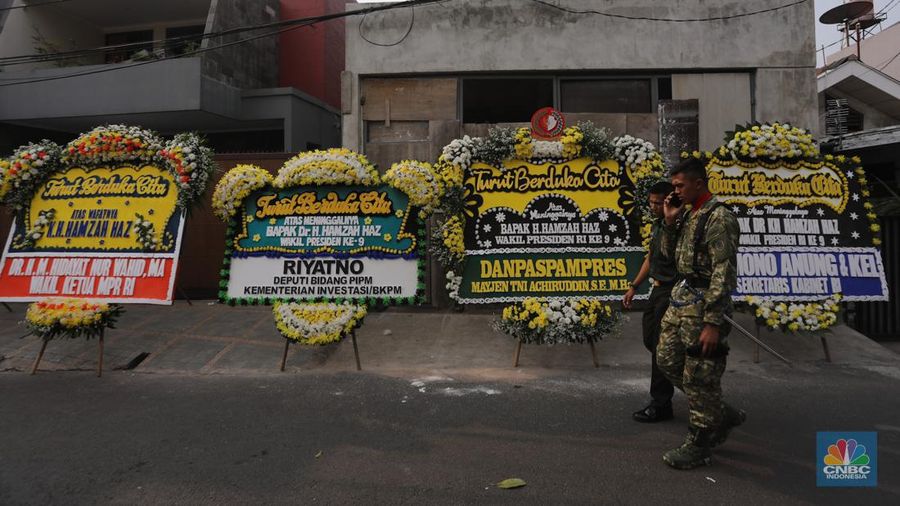 Warga berjalan di dekat karangan bunga duka cita di rumah duka Wakil Presiden ke-9 Hamzah Haz di Jalan Tegalan, Matraman, Jakarta, Rabu (24/7/2024). (CNBC Indonesia/Faisal Rahman)