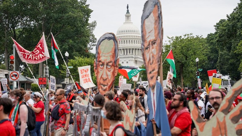 Orang-orang membawa gambar Perdana Menteri Israel Benjamin Netanyahu dan Presiden AS Joe Biden, saat demonstran Pro-Palestina melakukan protes, pada hari pidato Netanyahu di pertemuan gabungan Kongres AS, di Capitol Hill di Washington, AS, 24 Juli 2024. (REUTERS/Seth Herald)