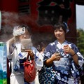 Women wearing summer kimonos take a break next to a cooling mist at the Sensoji temple as Japanese government issued heat stroke alerts in 39 of the country's 47 prefectures in Tokyo, Japan July 22, 2024.  REUTERS/Issei Kato