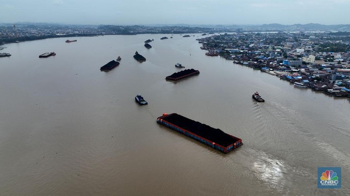 Foto udara menujukkan sejumlah perahu tongkang batu bara melintas di Sungai Mahakam, Kota Samarinda, Kalimantan Timur, Rabu (24/7/2024). Sungai Mahakam berfungsi sebagai jalur pengangkutan batu bara. Setiap hari di sungai ini dipadati tongkang yang membawa muatan batu bara. (CNBC Indonesia/Tri Susilo)