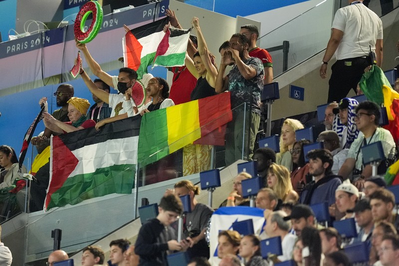 Penonton memegang bendera Palestina saat menonton pertandingan grup D putra antara Israel dan Mali di Parc des Princes selama Olimpiade Musim Panas 2024, Rabu, 24 Juli 2024, di Paris, Prancis. Penonton memegang bendera Palestina saat menonton pertandingan grup D putra antara Israel dan Mali di Parc des Princes selama Olimpiade Musim Panas 2024, Rabu, 24 Juli 2024, di Paris, Prancis. (AP Photo/Aurelien Morissard)