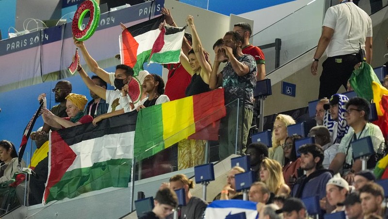 Penonton memegang bendera Palestina saat menonton pertandingan grup D putra antara Israel dan Mali di Parc des Princes selama Olimpiade Musim Panas 2024, Rabu, 24 Juli 2024, di Paris, Prancis. (AP Photo/Aurelien Morissard)