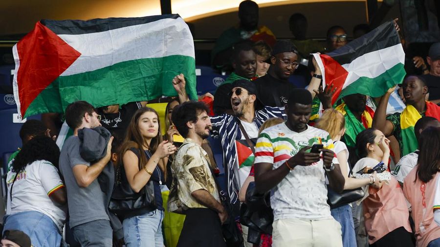 Penonton memegang bendera Palestina saat menonton pertandingan grup D putra antara Israel dan Mali di Parc des Princes selama Olimpiade Musim Panas 2024, Rabu, 24 Juli 2024, di Paris, Prancis. (AP Photo/Aurelien Morissard)