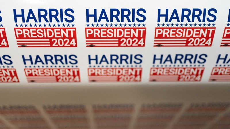 Juru cetak sablon Chris Fleury meletakkan kaus yang baru dicetak untuk mendukung kampanye kepresidenan Wakil Presiden AS Kamala Harris ke mesin pengering konveyor di Pabrik Gloo di Tucson, Arizona, AS, 25 Juli 2024. (REUTERS/Rebecca Noble)
