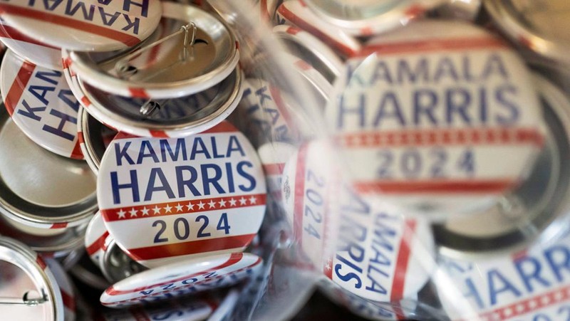 Juru cetak sablon Chris Fleury meletakkan kaus yang baru dicetak untuk mendukung kampanye kepresidenan Wakil Presiden AS Kamala Harris ke mesin pengering konveyor di Pabrik Gloo di Tucson, Arizona, AS, 25 Juli 2024. (REUTERS/Rebecca Noble)