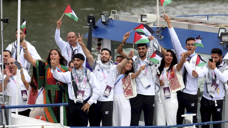 Kontingen Palestina mengikuti defie dengan menaiki kapal menyusuri sungai Seine jauh 6 km saat Pembukaan Olimpiade 2024 di Paris, Prancis, Jumat (26/7/2024). (Michael Reaves/Pool Photo via AP)