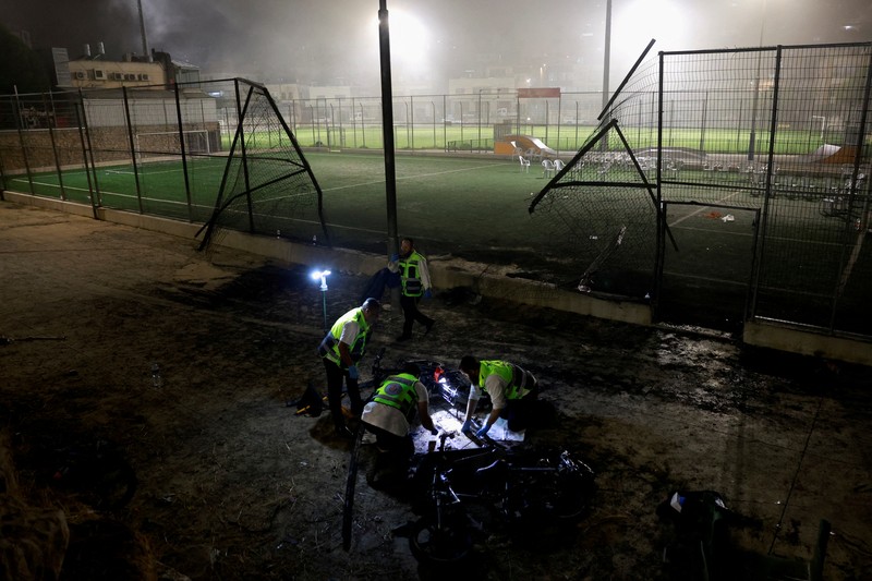 Warga menolong anak-anak yang terluka beberapa saat setelah serangan roket Hizbullah di Majdal Shams, Dataran Tinggi Golan yang diduduki Israel, Sabtu (27/7/2024). (AP Photo/Hassan Shams)