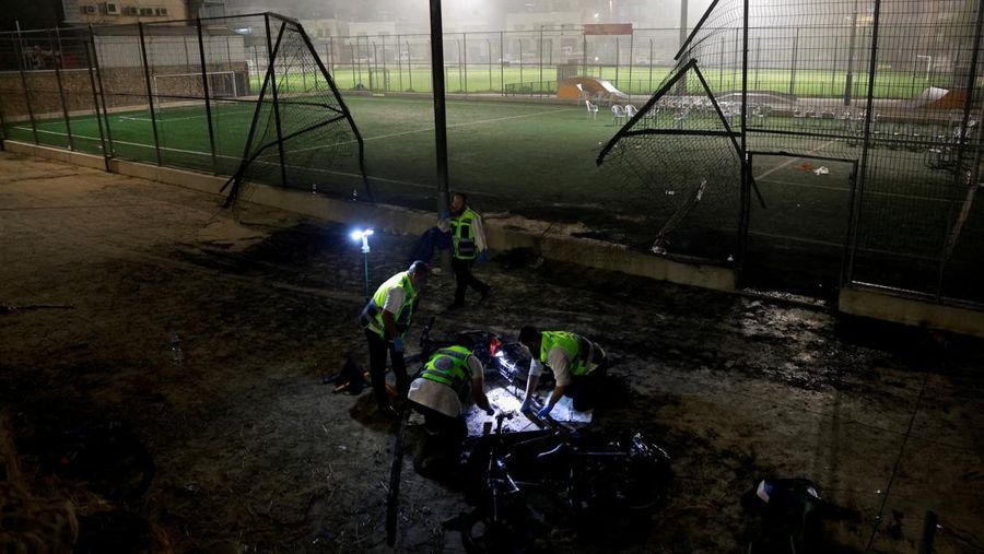 Warga menolong anak-anak yang terluka beberapa saat setelah serangan roket Hizbullah di Majdal Shams, Dataran Tinggi Golan yang diduduki Israel, Sabtu (27/7/2024). (AP Photo/Hassan Shams)