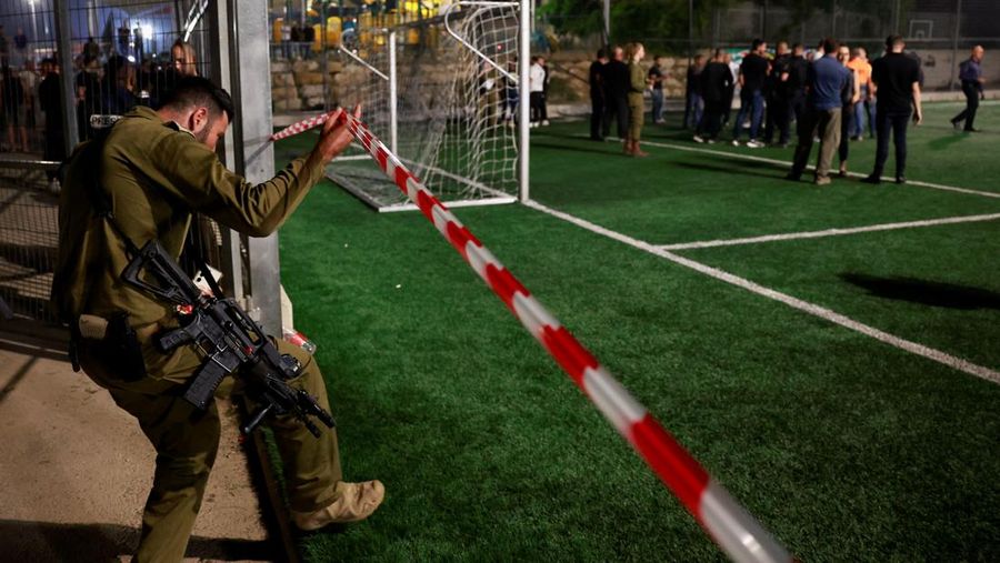 Warga menolong anak-anak yang terluka beberapa saat setelah serangan roket Hizbullah di Majdal Shams, Dataran Tinggi Golan yang diduduki Israel, Sabtu (27/7/2024). (AP Photo/Hassan Shams)