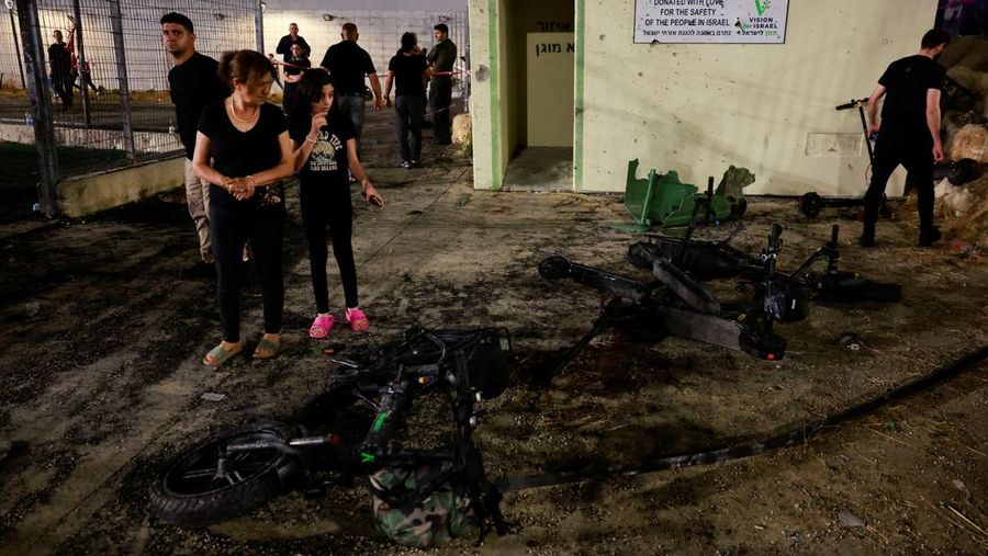 Warga menolong anak-anak yang terluka beberapa saat setelah serangan roket Hizbullah di Majdal Shams, Dataran Tinggi Golan yang diduduki Israel, Sabtu (27/7/2024). (AP Photo/Hassan Shams)