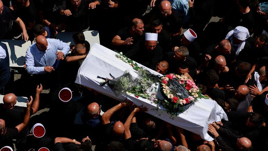 Warga berkumpul mengantarkan jenazah saat pemakaman  anak-anak yang tewas pada sebuah lapangan sepak bola akibat serangan roket Hizbullah di Desa Druze, Dataran Tinggi Golan yang dikuasai Israel, Minggu (28/7/2024). (REUTERS/Ammar Awad)