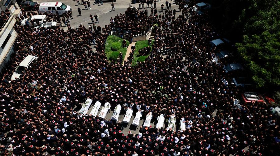 Warga berkumpul mengantarkan jenazah saat pemakaman  anak-anak yang tewas pada sebuah lapangan sepak bola akibat serangan roket Hizbullah di Desa Druze, Dataran Tinggi Golan yang dikuasai Israel, Minggu (28/7/2024). (REUTERS/Ammar Awad)