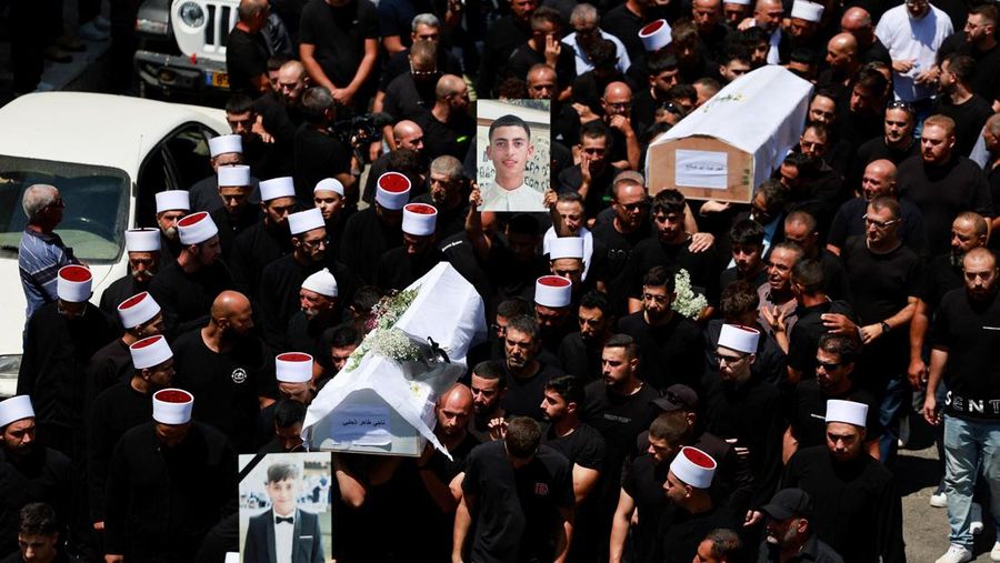 Warga berkumpul mengantarkan jenazah saat pemakaman  anak-anak yang tewas pada sebuah lapangan sepak bola akibat serangan roket Hizbullah di Desa Druze, Dataran Tinggi Golan yang dikuasai Israel, Minggu (28/7/2024). (REUTERS/Ammar Awad)
