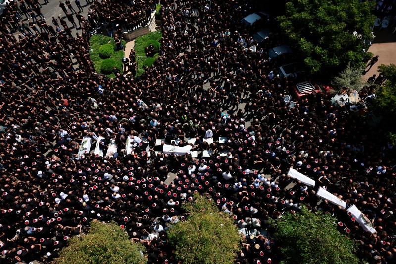 Warga berkumpul mengantarkan jenazah saat pemakaman  anak-anak yang tewas pada sebuah lapangan sepak bola akibat serangan roket Hizbullah di Desa Druze, Dataran Tinggi Golan yang dikuasai Israel, Minggu (28/7/2024). (REUTERS/Ammar Awad)