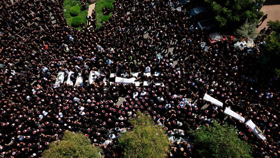 Warga berkumpul mengantarkan jenazah saat pemakaman  anak-anak yang tewas pada sebuah lapangan sepak bola akibat serangan roket Hizbullah di Desa Druze, Dataran Tinggi Golan yang dikuasai Israel, Minggu (28/7/2024). (REUTERS/Ammar Awad)