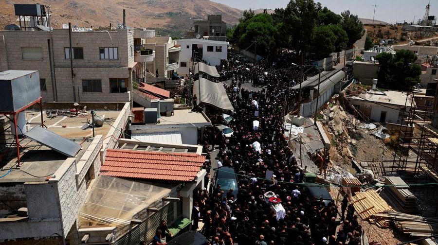 Warga berkumpul mengantarkan jenazah saat pemakaman  anak-anak yang tewas pada sebuah lapangan sepak bola akibat serangan roket Hizbullah di Desa Druze, Dataran Tinggi Golan yang dikuasai Israel, Minggu (28/7/2024). (REUTERS/Ammar Awad)