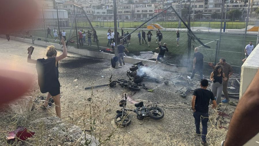 Warga menolong anak-anak yang terluka beberapa saat setelah serangan roket Hizbullah di Majdal Shams, Dataran Tinggi Golan yang diduduki Israel, Sabtu (27/7/2024). (AP Photo/Hassan Shams)