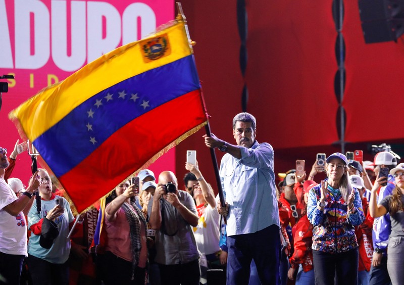 Presiden Venezuela Nicolas Maduro, yang sedang mencalonkan diri untuk masa jabatan ketiga, mengibarkan bendera nasional Venezuela saat penutupan kampanye politiknya, di Caracas, Venezuela, 25 Juli 2024. (REUTERS/Fausto Torrealba)