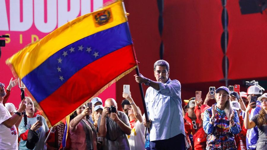 Presiden Venezuela Nicolas Maduro, yang sedang mencalonkan diri untuk masa jabatan ketiga, mengibarkan bendera nasional Venezuela saat penutupan kampanye politiknya, di Caracas, Venezuela, 25 Juli 2024. (REUTERS/Fausto Torrealba)