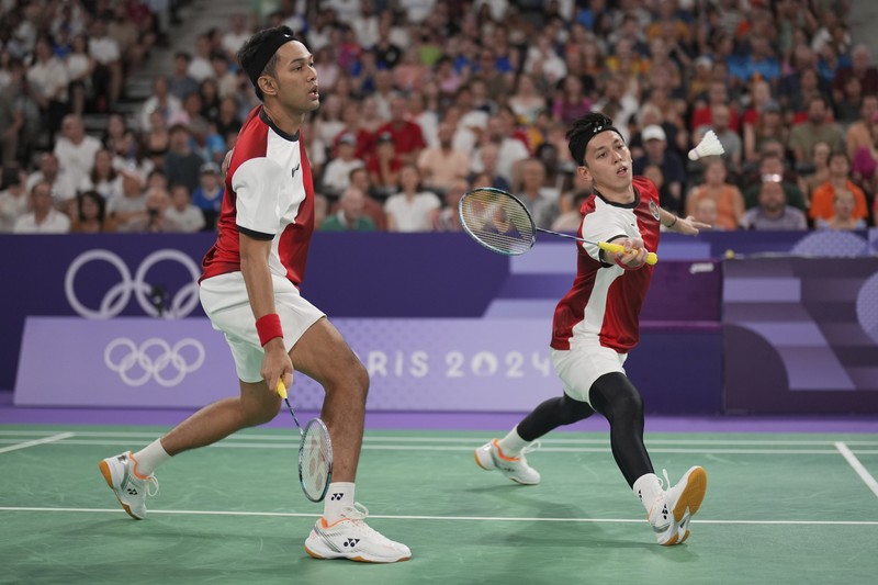 Pebulu tangkis ganda putra Indonesia Fajar Alfian/Muhammad Rian Ardianto saat menghadappi ganda putra India Chirag Shetty/Satwiksairaj Rankireddypada grup C Olimpiade 2024 di Porte de la Chapelle Arena, Paris Prancis Selasa (30/7/2024).  (AP Photo/Kin Cheung)