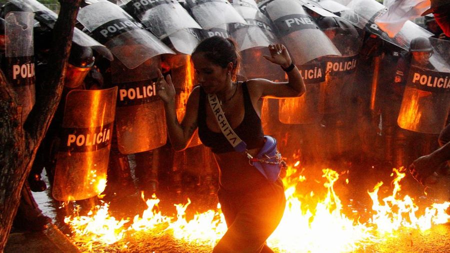 Seorang demonstran berlari ketika bom molotov menghantam tanah di depan pasukan keamanan selama protes terhadap hasil pemilu setelah Presiden Venezuela Nicolas Maduro dan saingan oposisinya Edmundo Gonzalez mengklaim kemenangan dalam pemilihan presiden hari Minggu, di Puerto La Cruz, Venezuela, 29 Juli 2024. (REUTERS/Samir Aponte)