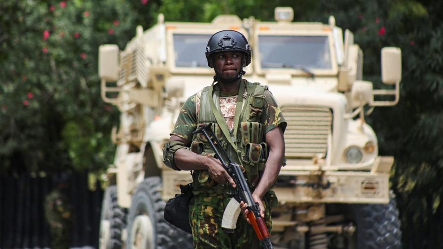 Seorang polisi Kenya berjalan di depan pengangkut personel lapis baja selama operasi gabungan dengan polisi Haiti, di Port-au-Prince, Haiti, 29 Juli 2024. (REUTERS/Jean Feguens Regala)