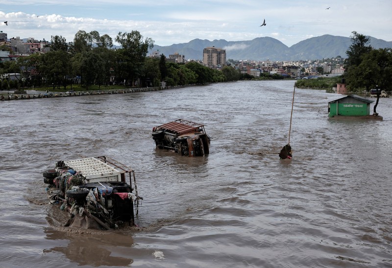 Kendaraan yang terendam sebagian terlihat di daerah banjir di sepanjang tepi Sungai Bagmati yang meluap setelah hujan lebat di Kathmandu, Nepal, 31 Juli 2024. (REUTERS/Navesh Chitrakar)
