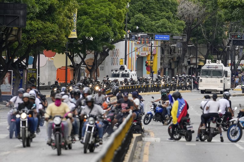 Para pengunjuk rasa mengendari sepeda motor saat berdemonstrasi menentang hasil resmi pemilu yang menyatakan Presiden Nicolas Maduro menang dalam pemilihan ulang di Caracas, Venezuela, Selasa (30/7/2024). (AP Photo/Cristian Hernandez)