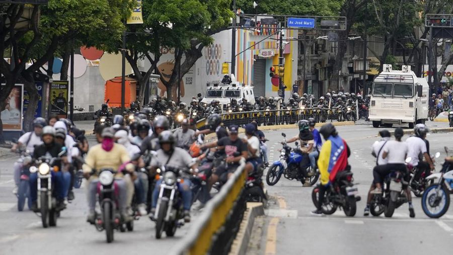 Para pengunjuk rasa mengendari sepeda motor saat berdemonstrasi menentang hasil resmi pemilu yang menyatakan Presiden Nicolas Maduro menang dalam pemilihan ulang di Caracas, Venezuela, Selasa (30/7/2024). (AP Photo/Cristian Hernandez)