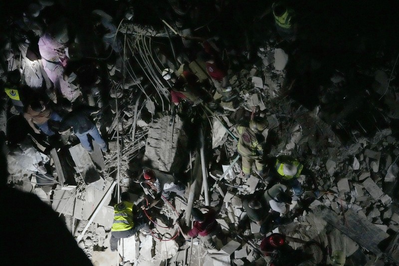 Warga berkumup di dekat lokasi serangan Israel di pinggiran selatan Beirut, Lebanon, Selasa (30/7/2024). (AP Photo/Hussein Malla)