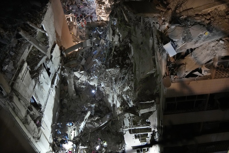 Warga berkumup di dekat lokasi serangan Israel di pinggiran selatan Beirut, Lebanon, Selasa (30/7/2024). (AP Photo/Hussein Malla)