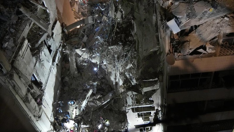 Warga berkumup di dekat lokasi serangan Israel di pinggiran selatan Beirut, Lebanon, Selasa (30/7/2024). (AP Photo/Hussein Malla)