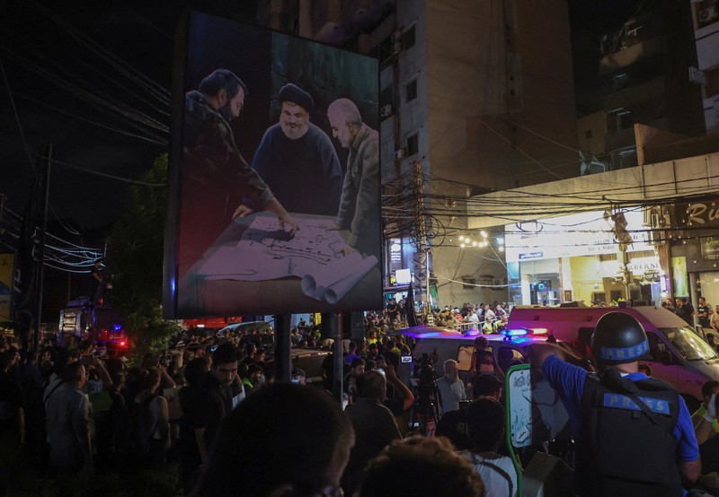 Warga berkumup di dekat lokasi serangan Israel di pinggiran selatan Beirut, Lebanon, Selasa (30/7/2024). (AP Photo/Hussein Malla) Warga berkumup di dekat lokasi serangan Israel di pinggiran selatan Beirut, Lebanon, Selasa (30/7/2024). (AP Photo/Hussein Malla)