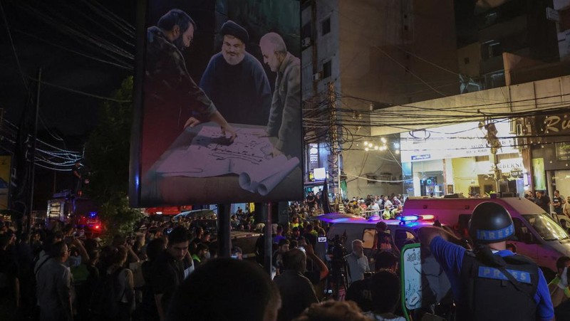 Warga berkumup di dekat lokasi serangan Israel di pinggiran selatan Beirut, Lebanon, Selasa (30/7/2024). (AP Photo/Hussein Malla)