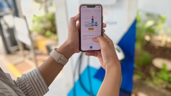 Pelanggan menggunakan fitur EV pada aplikasi PLN Mobile saat akan melakukan pengisian daya di Stasiun Pengisian Kendaraan Listrik Umum (SPKLU). (Dok. PT PLN (Persero))