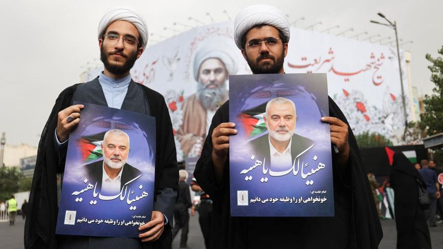 Warga Iran memegang poster pemimpin Hamas yang dibunuh, Ismail Haniyeh selama prosesi pemakamannya, di Teheran, Iran, 1 Agustus 2024. (Majid Asgaripour/WANA (West Asia News Agency) via REUTERS)