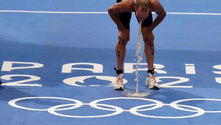 Atlet triatlon asal Kanada Tyler Mislawchuk terlihat muntah setelah melewati garis finis. (Instagram @therealmislawchuk)