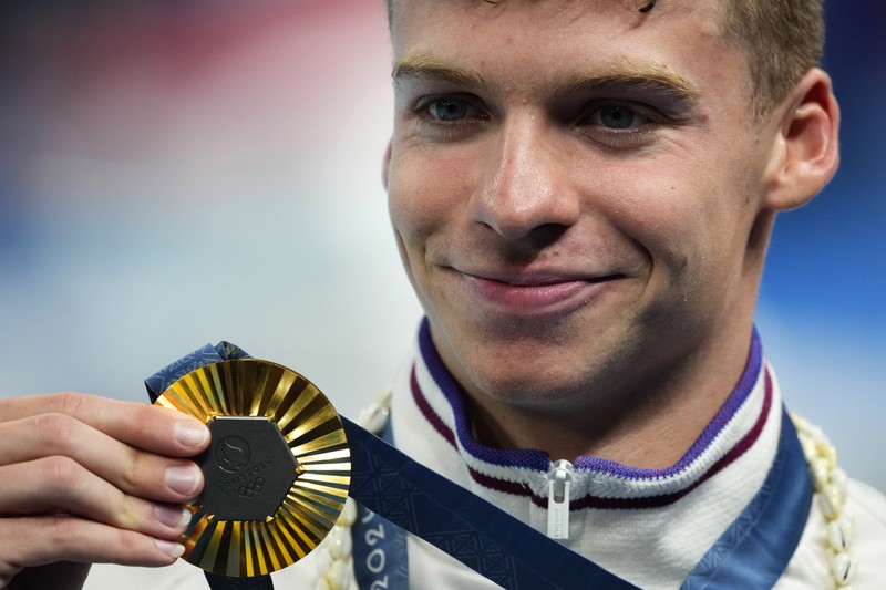 Peraih medali emas Leon Marchand bereaksi saat berdiri di podium pemenang setelah final gaya dada 200 meter putra di Olimpiade Musim Panas 2024, Rabu, 31 Juli 2024, di Nanterre, Prancis. (AP Photo/Matthias Schrader)