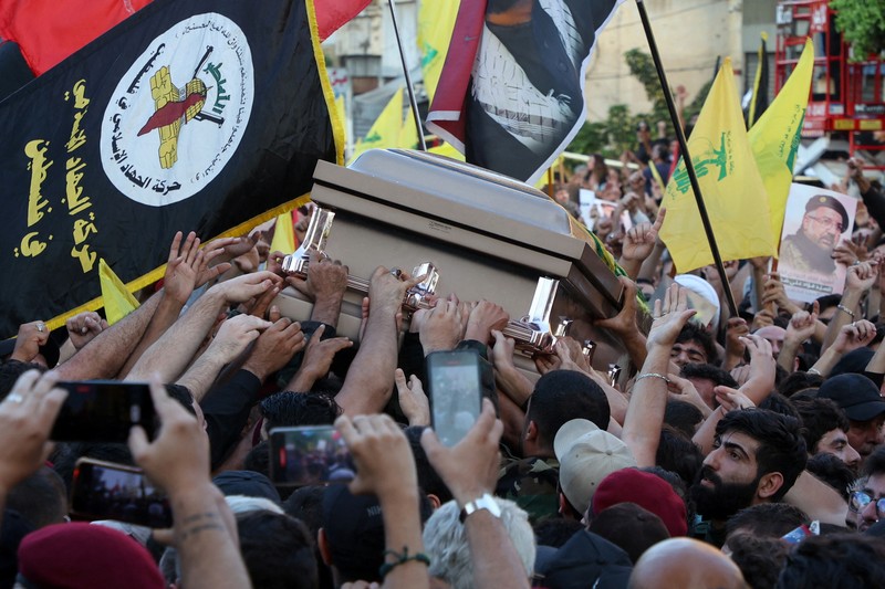 Anggota Hizbullah membawa peti jenazah Fuad Shukr, seorang komandan senior Hizbullah yang tewas akibat serangan Israel pada hari Selasa, selama pemakamannya di pinggiran selatan Beirut, Lebanon, 1 Agustus 2024. (REUTERS/Alkis Konstantinidis)