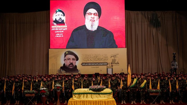 Pemimpin Hizbullah Lebanon Sayyed Hassan Nasrallah muncul di layar saat berbicara kepada para pendukungnya, selama pemakaman komandan senior Hizbullah Fuad Shukr, yang tewas dalam serangan Israel, di pinggiran selatan Beirut, Lebanon, 1 Agustus 2024. (REUTERS/Alkis Konstantinidis)