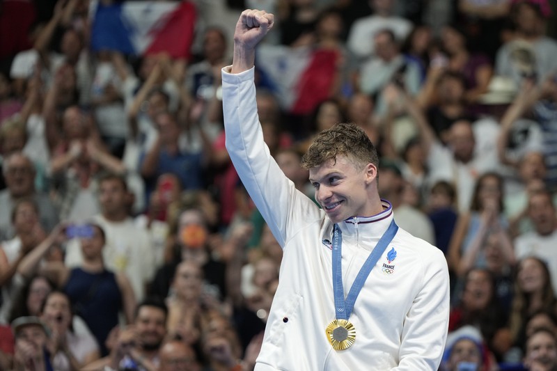 Peraih medali emas Leon Marchand bereaksi saat berdiri di podium pemenang setelah final gaya dada 200 meter putra di Olimpiade Musim Panas 2024, Rabu, 31 Juli 2024, di Nanterre, Prancis. (AP Photo/Matthias Schrader)