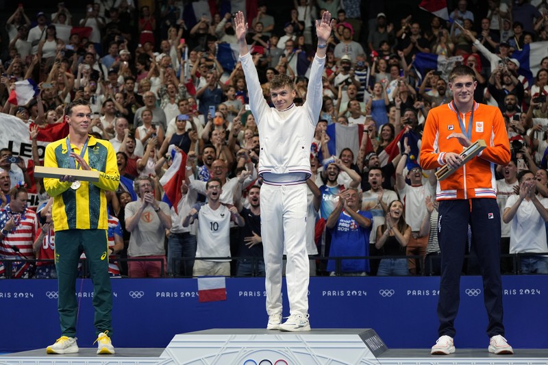 Peraih medali emas Leon Marchand bereaksi saat berdiri di podium pemenang setelah final gaya dada 200 meter putra di Olimpiade Musim Panas 2024, Rabu, 31 Juli 2024, di Nanterre, Prancis. (AP Photo/Matthias Schrader)
