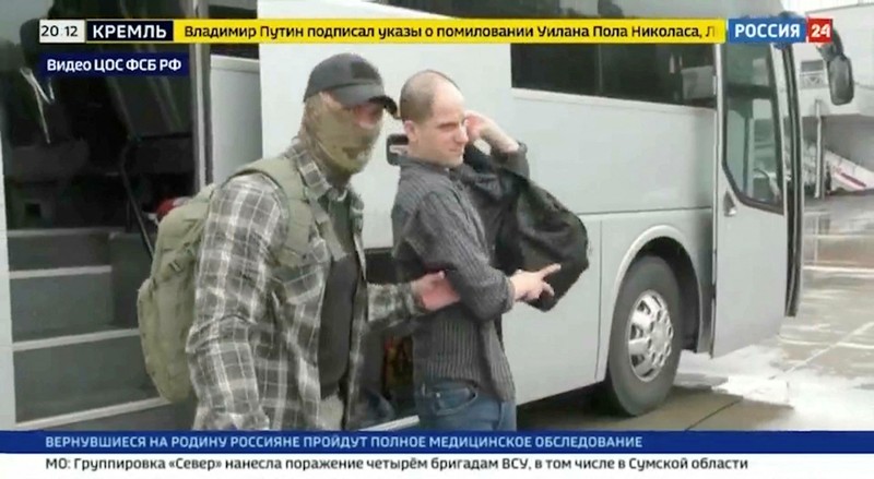RUSSIA-USA/PRISONERS U.S. journalist Evan Gershkovich is escorted by a federal security service officer before boarding a plane during a prisoner exchange between Russia with Western countries at an undisclosed location, in this still image from August 1, 2024 broadcast video. FSB Public Relations Centre/ROSSIYA 24 TV Channel via REUTERS ATTENTION EDITORS - THIS IMAGE HAS BEEN SUPPLIED BY A THIRD PARTY. NO RESALES. NO ARCHIVES. MANDATORY CREDIT. WATERMARK AND TV GRAPHICS FROM SOURCE.