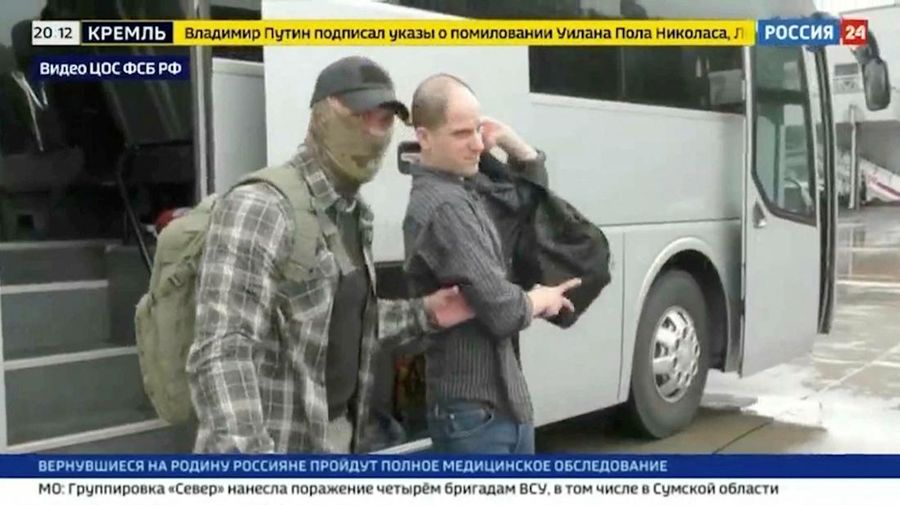U.S. journalist Evan Gershkovich is escorted by a federal security service officer before boarding a plane during a prisoner exchange between Russia with Western countries at an undisclosed location, in this still image from August 1, 2024 broadcast video. FSB Public Relations Centre/ROSSIYA 24 TV Channel via REUTERS ATTENTION EDITORS - THIS IMAGE HAS BEEN SUPPLIED BY A THIRD PARTY. NO RESALES. NO ARCHIVES. MANDATORY CREDIT. WATERMARK AND TV GRAPHICS FROM SOURCE.