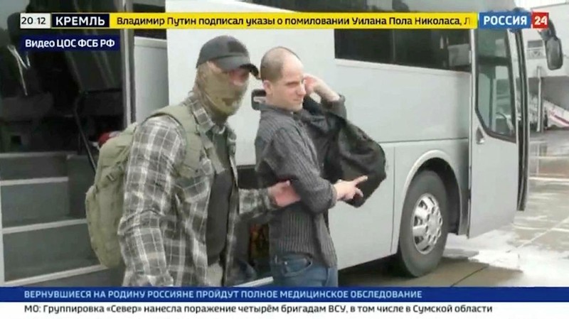 U.S. journalist Evan Gershkovich is escorted by a federal security service officer before boarding a plane during a prisoner exchange between Russia with Western countries at an undisclosed location, in this still image from August 1, 2024 broadcast video. FSB Public Relations Centre/ROSSIYA 24 TV Channel via REUTERS ATTENTION EDITORS - THIS IMAGE HAS BEEN SUPPLIED BY A THIRD PARTY. NO RESALES. NO ARCHIVES. MANDATORY CREDIT. WATERMARK AND TV GRAPHICS FROM SOURCE.