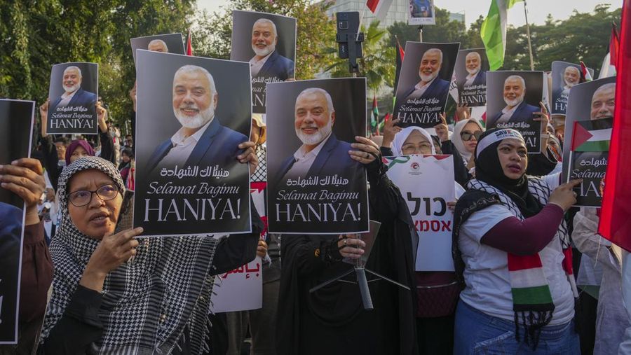 Protesters hold a poster of Hamas leader Ismail Haniyeh, who was assassinated in Tehran, during a rally in support of the Palestinians in Gaza, outside the U.S. Embassy in Jakarta, Indonesia, Saturday, Aug. 3, 2024. (AP Photo/Tatan Syuflana)