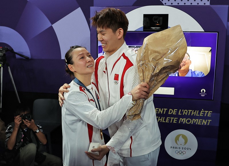 OLYMPICS-2024-BADMINTON/ Paris 2024 Olympics - Badminton - Mixed Doubles Victory Ceremony - Porte de La Chapelle Arena, Paris, France - August 02, 2024. Si Wei Zheng of China proposes to Ya Qiong Huang of China after winning the gold. REUTERS/Ann Wang