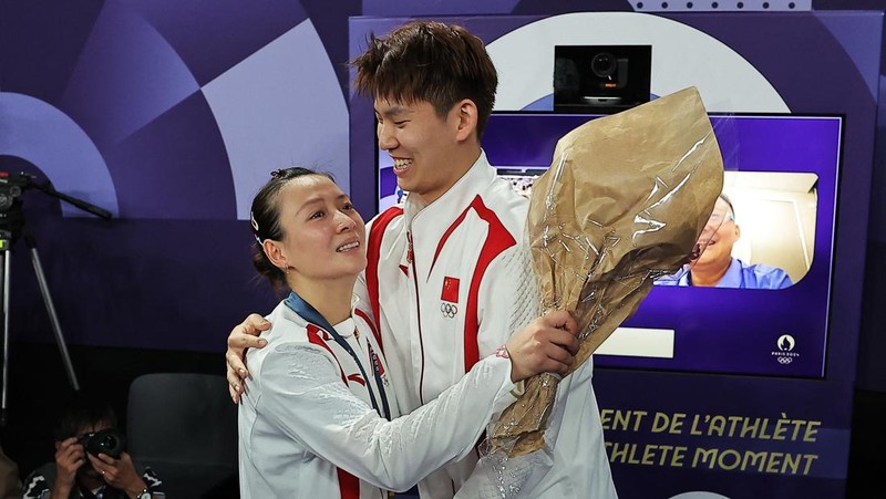 Paris 2024 Olympics - Badminton - Mixed Doubles Victory Ceremony - Porte de La Chapelle Arena, Paris, France - August 02, 2024. Si Wei Zheng of China proposes to Ya Qiong Huang of China after winning the gold. REUTERS/Ann Wang